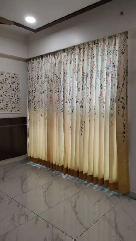 Cream curtains with a hand-painted floral print and mustard border, custom stitched and installed