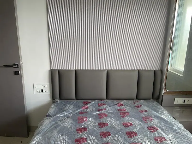 Grey channel-panel headboard fitted below fluted wall panelling in a new flat