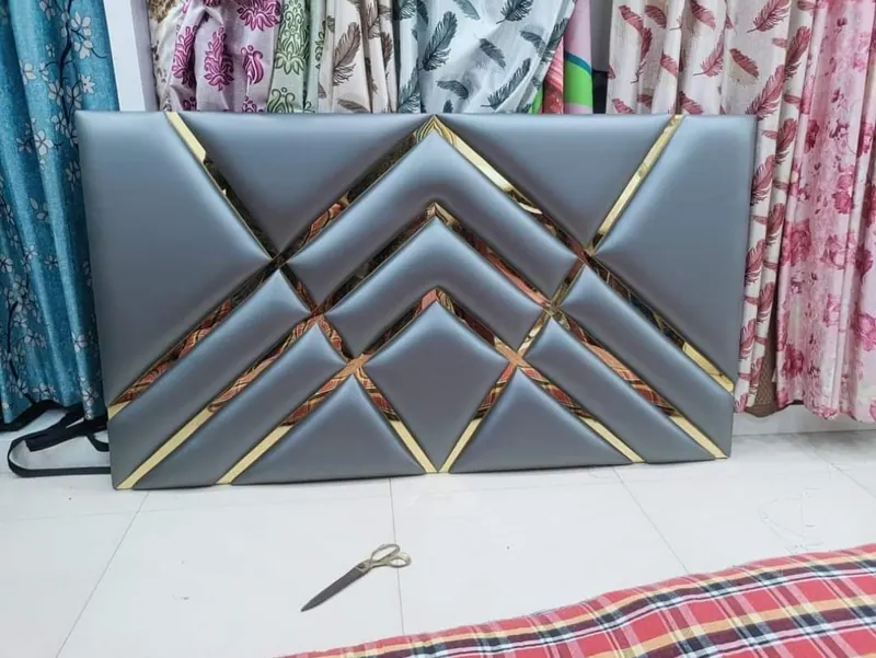 Grey leatherette headboard with chevron panels and gold inlay strips, built to order at the Thane workshop