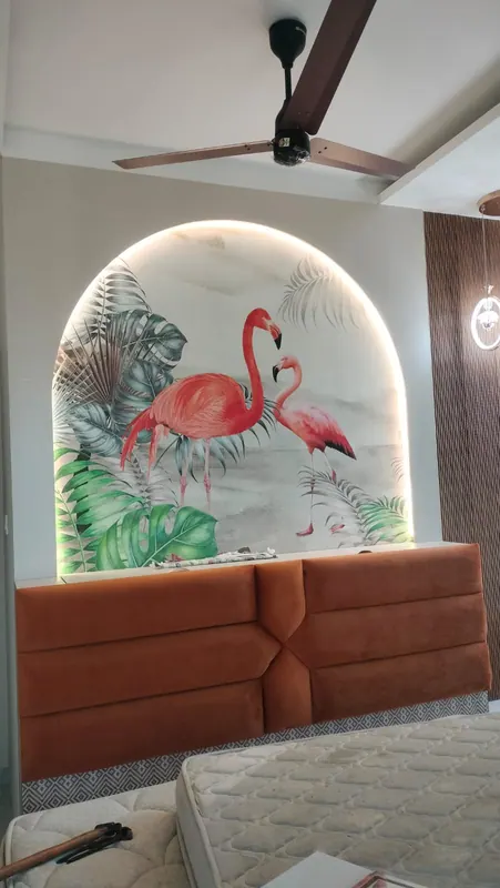 Rust velvet padded headboard set beneath a backlit arch with flamingo mural wallpaper