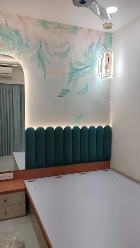 Teal velvet scalloped headboard panel with a pastel floral mural wallpaper above it