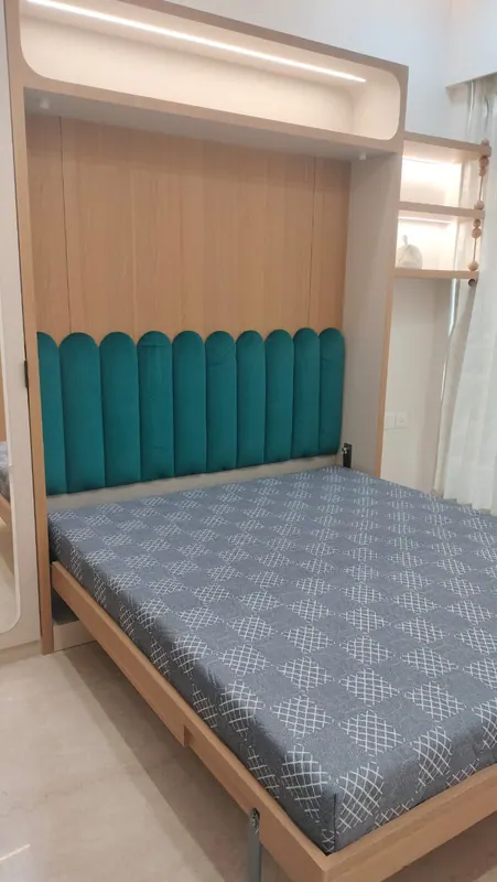 Teal scalloped headboard fitted to a wall-mounted foldaway bed in oak laminate
