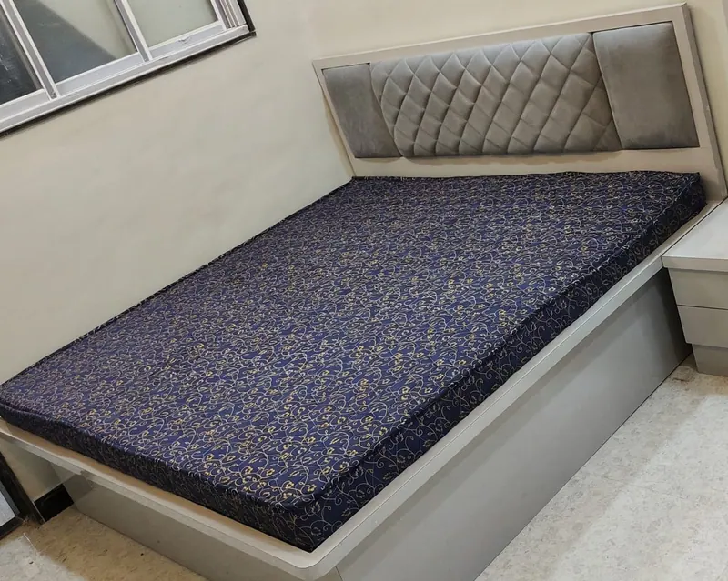 Navy and gold printed mattress cut to size for a storage bed in a Thane bedroom, under a grey quilted headboard
