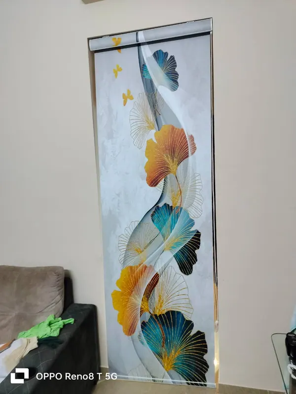 Digitally printed roller blind with teal and gold ginkgo leaves on a full-height window