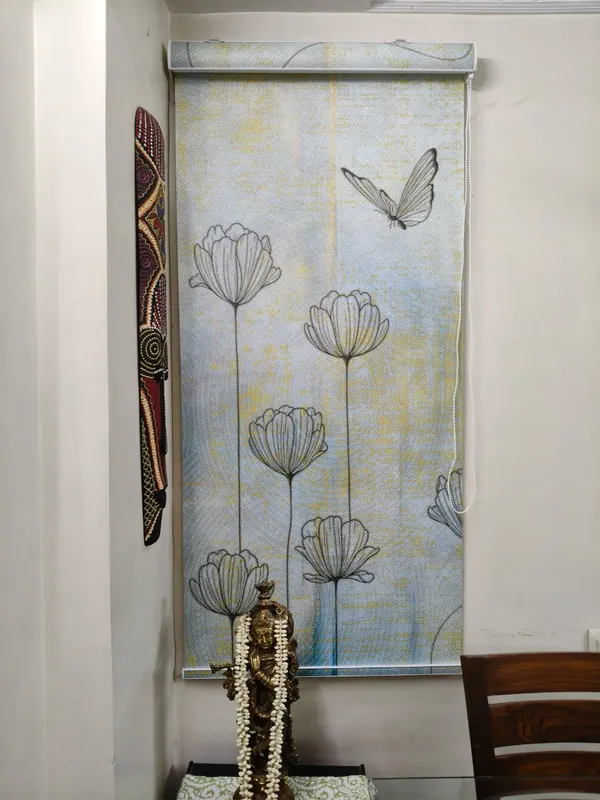Printed roller blind with line-drawn lotus flowers and a butterfly, fitted in a dining area