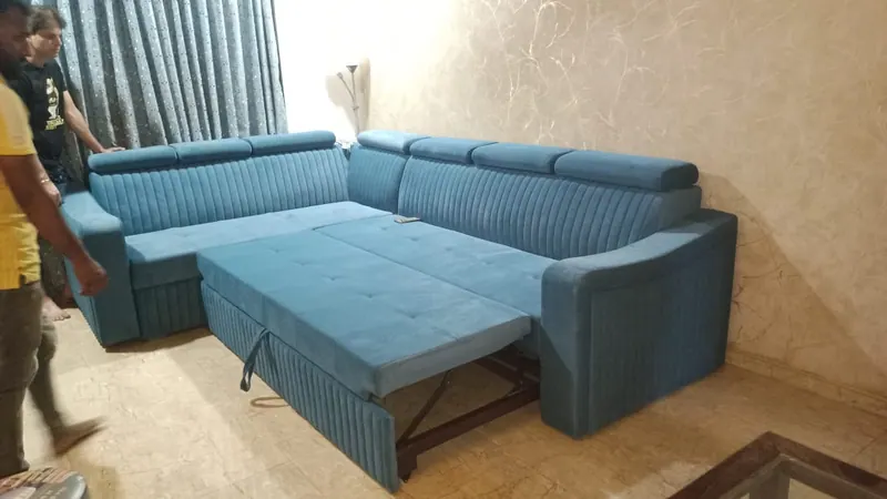 Blue L-shape sofa cum bed with adjustable headrests, opened into a bed