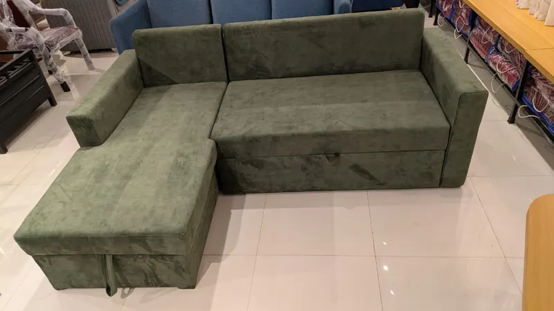 Olive green L-shape sofa cum bed in sofa position, with a storage chaise