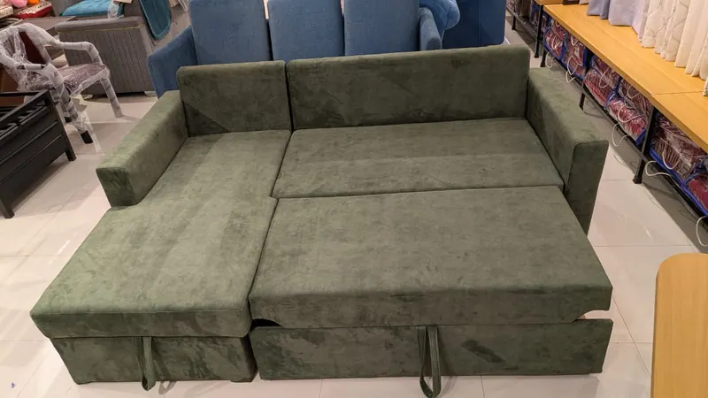 The same olive green sofa cum bed pulled out flat into a double bed