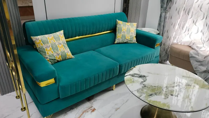 Teal velvet designer sofa with gold metal trim on the arms and back, custom built to order